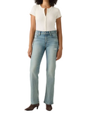 A model wearing light-wash blue straight-leg jeans, a cream ribbed short-sleeve top, and brown heeled boots, standing against a light gray studio background.