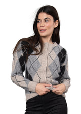 A woman wearing a fuzzy knit cardigan with a gray, black, and beige argyle pattern, posed against a solid gray studio background.
