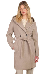 Woman wearing a beige coat with a hood on a plain background