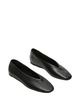 Pair of black flat shoes on a light gray background